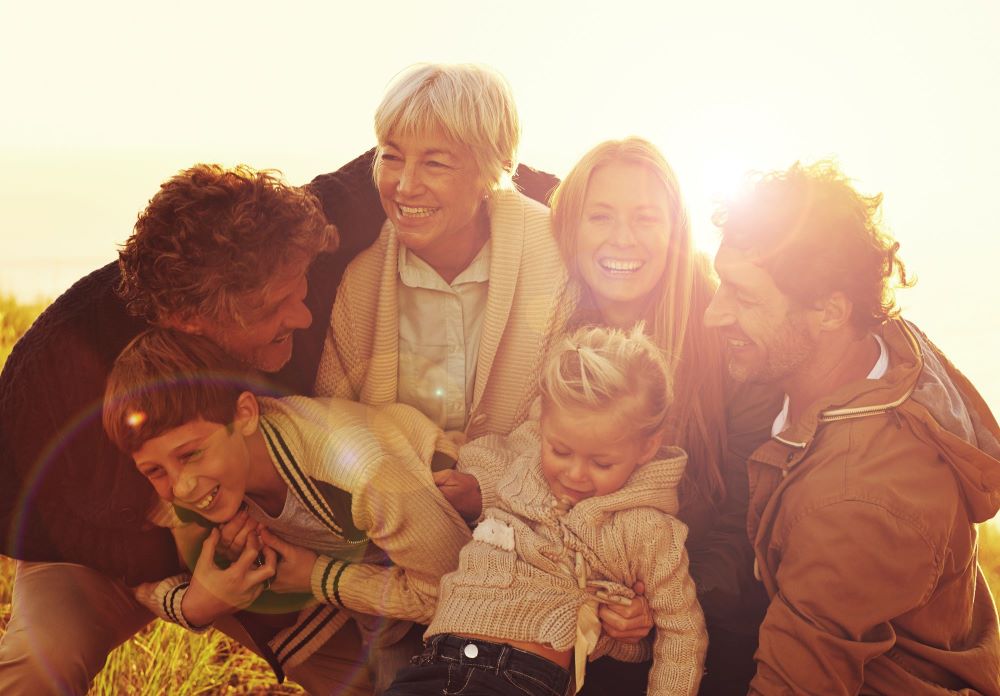 Big family outside smiling and hugging at sunset